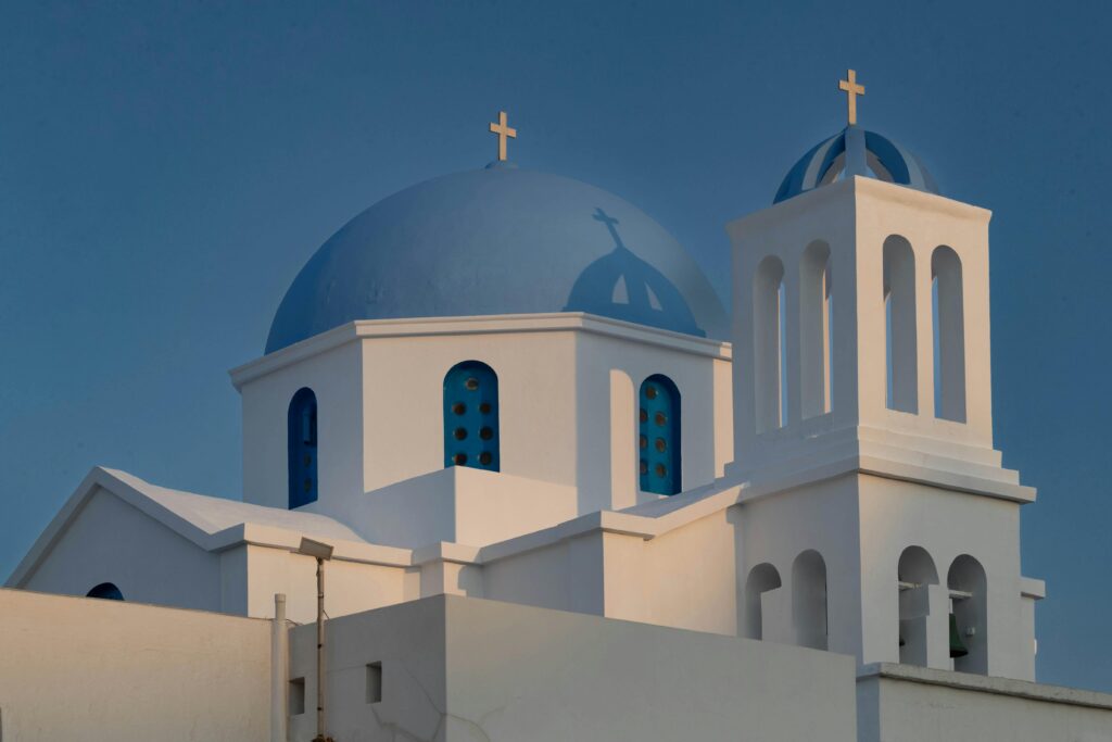 pexels-photo-16805689-16805689 Stunning view of a classic white and blue domed church in Folegandros, Greece.