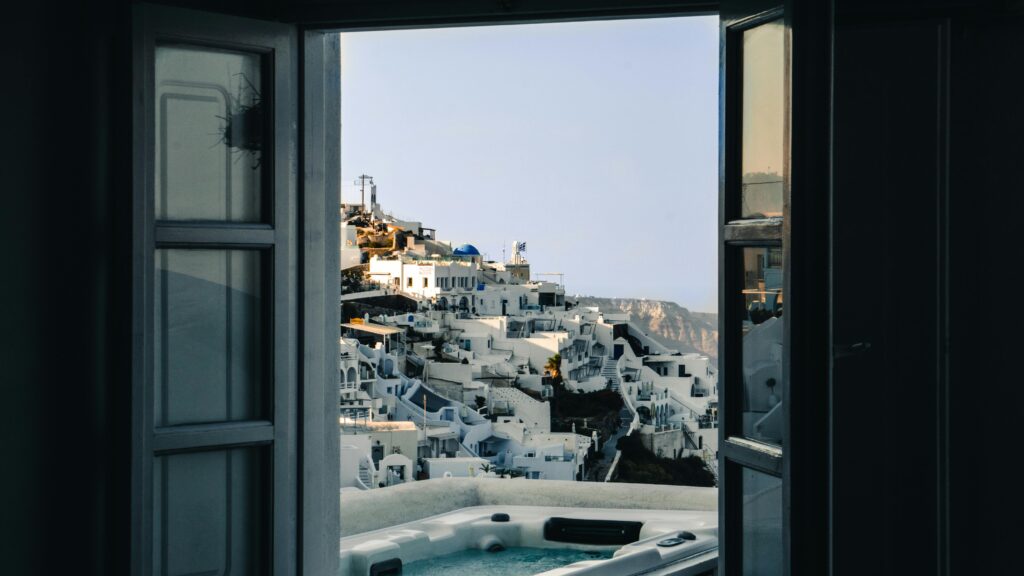 pexels-photo-2700087-2700087 Experience the breathtaking architecture of Santorini through this open window view.